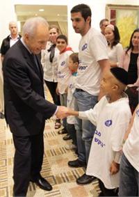 נשיא המדינה, שמעון פרס, לוחץ את ידיהם של הילדים אשר לקחו חלק בטקס המרגש. צילום רפי דלויה