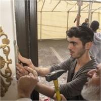 ערן ויצמן מציב מזוזה בדלת הכניסה של מרכז הסטיילינג החדש וגם מברך - צילום ערן מנוליאו