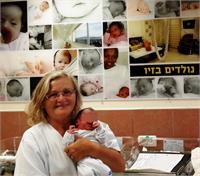 אתי עמבר, אחות אחראית מחלקת ילודים במרכז הרפואי זיו, עם תינוקת סורית שנולדה בבית החולים