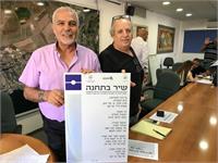 מאיר דותן ומאיר איבגי יחד עם מודל של המונומנט שיוצב ע"ג התחנות במיזם שיר בתחנה. קרדיט תמונות – דוברות והסברה עיריית טבריה.